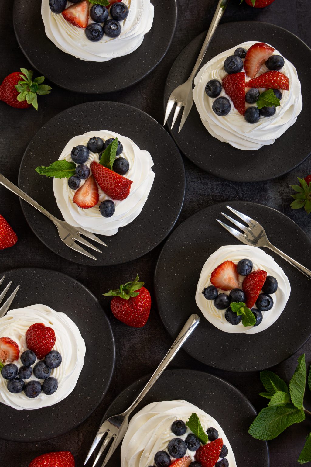 Mini Pavlovas topped with mascarpone cream and fresh berries