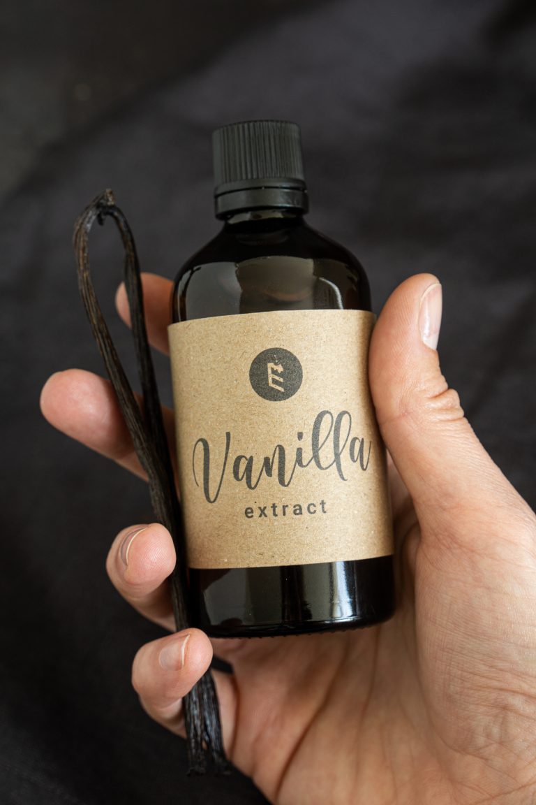 Dark glass bottle of homemade vanilla extract held in a hand