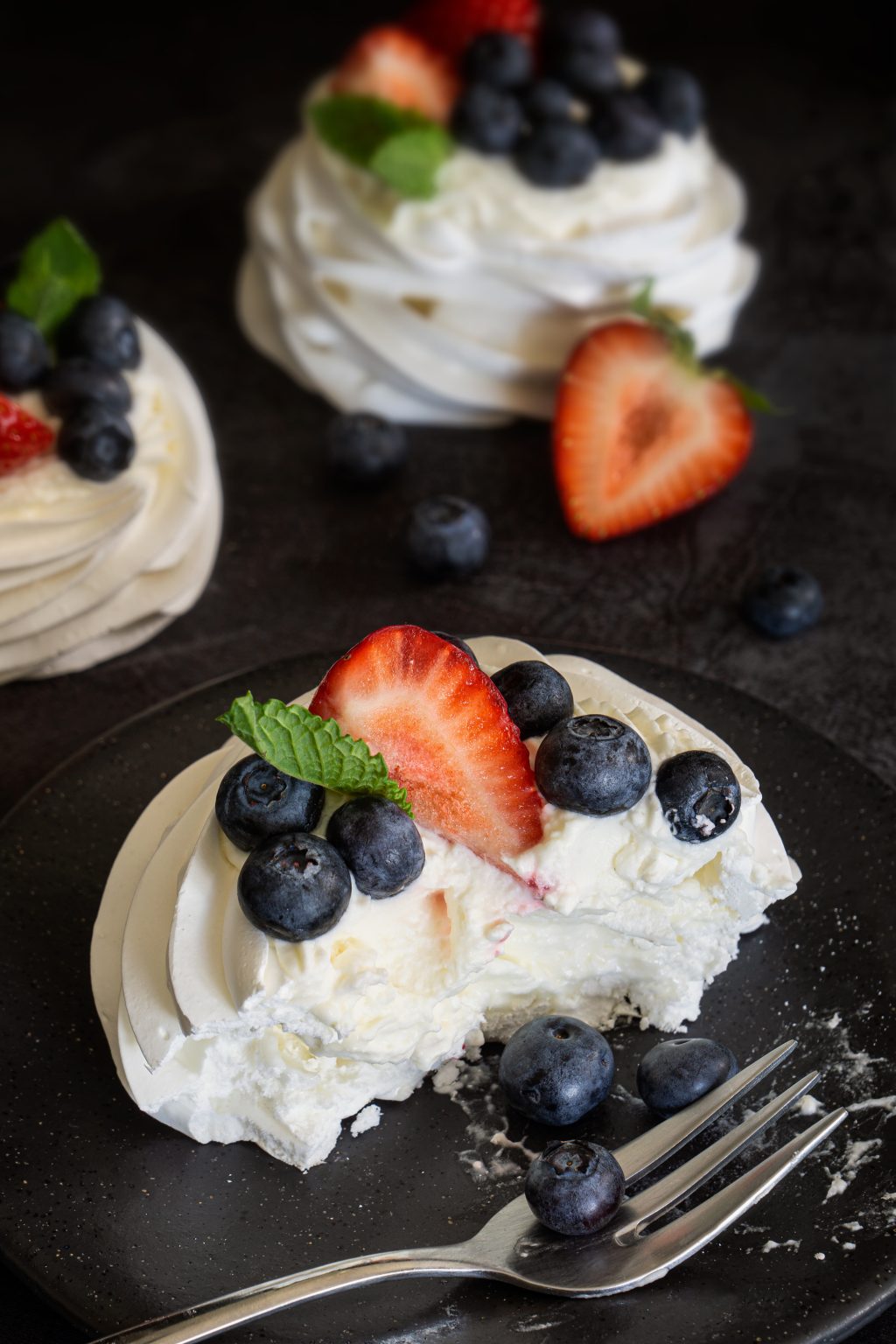 Mini Pavlovas topped with mascarpone cream and fresh berries