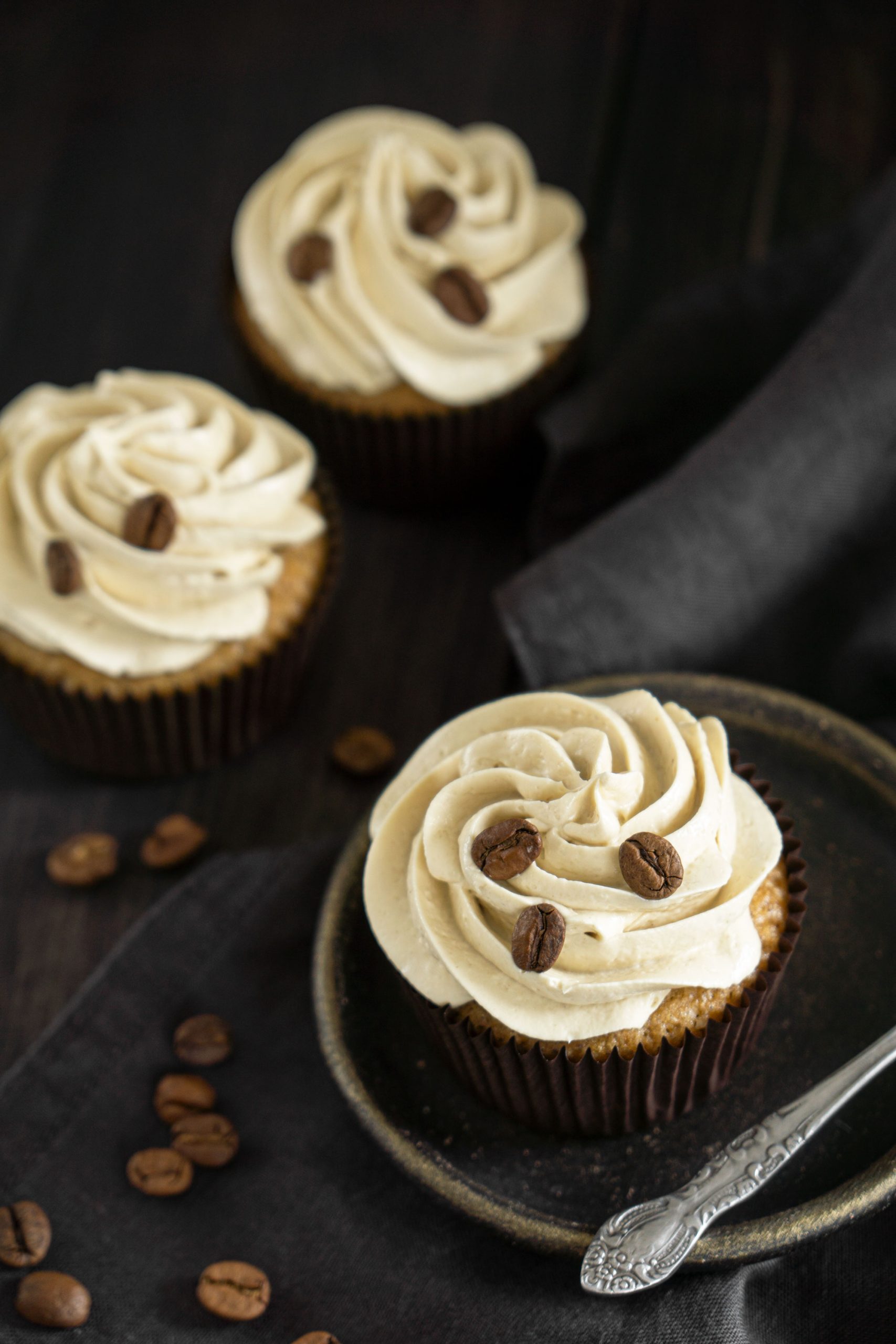 Close up of a coffee cupcakes decorated with buttercream and coffee beans
