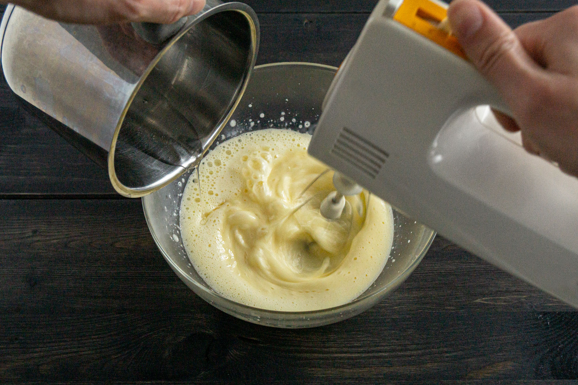 Drizzling sugar syrup into the egg yolks