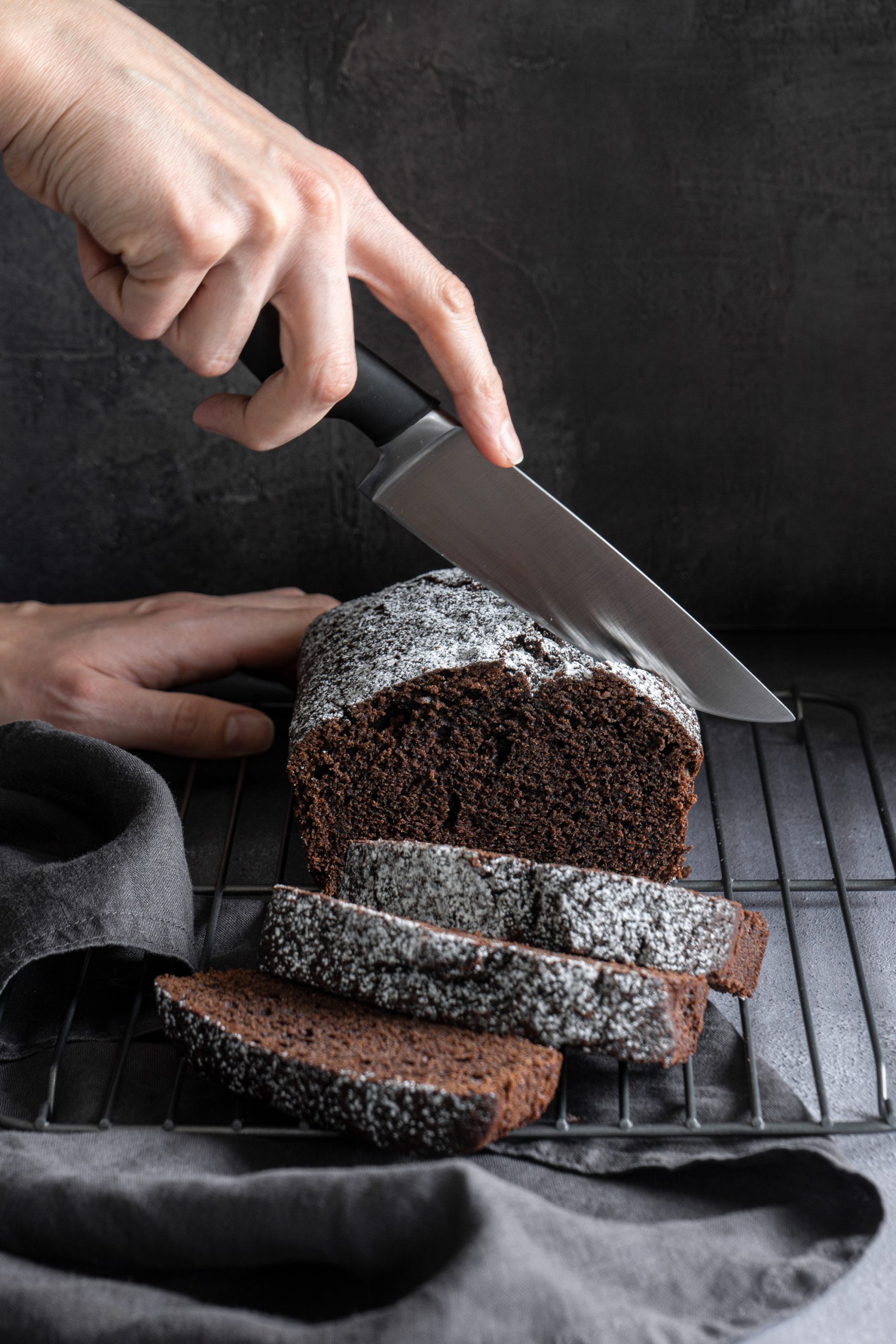 Moist chocolate loaf cake being sliced