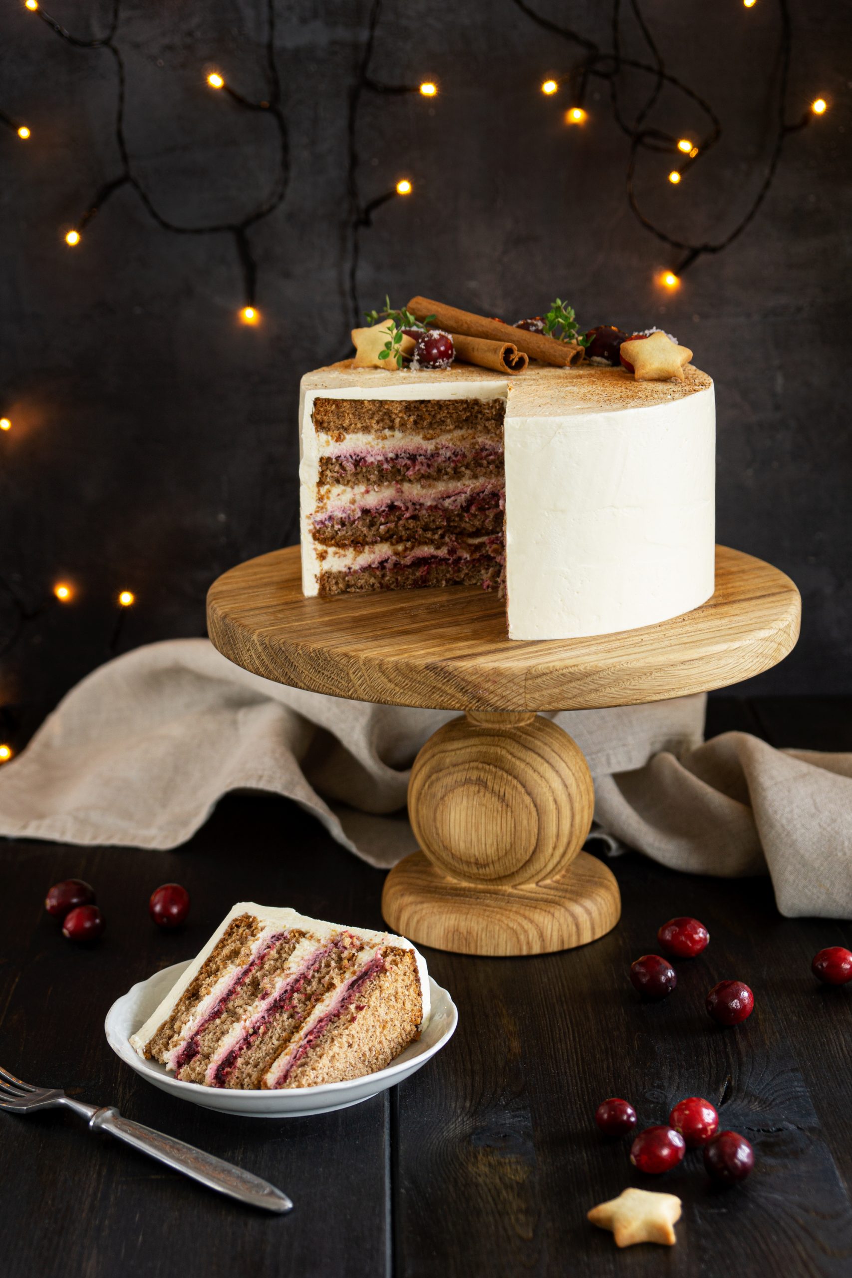 Sliced cranberry honey cake served on a wooden cake stand