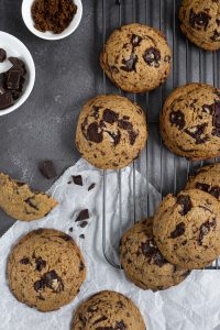 Flat lay composition of chocolate chip cookies on a dark grey background