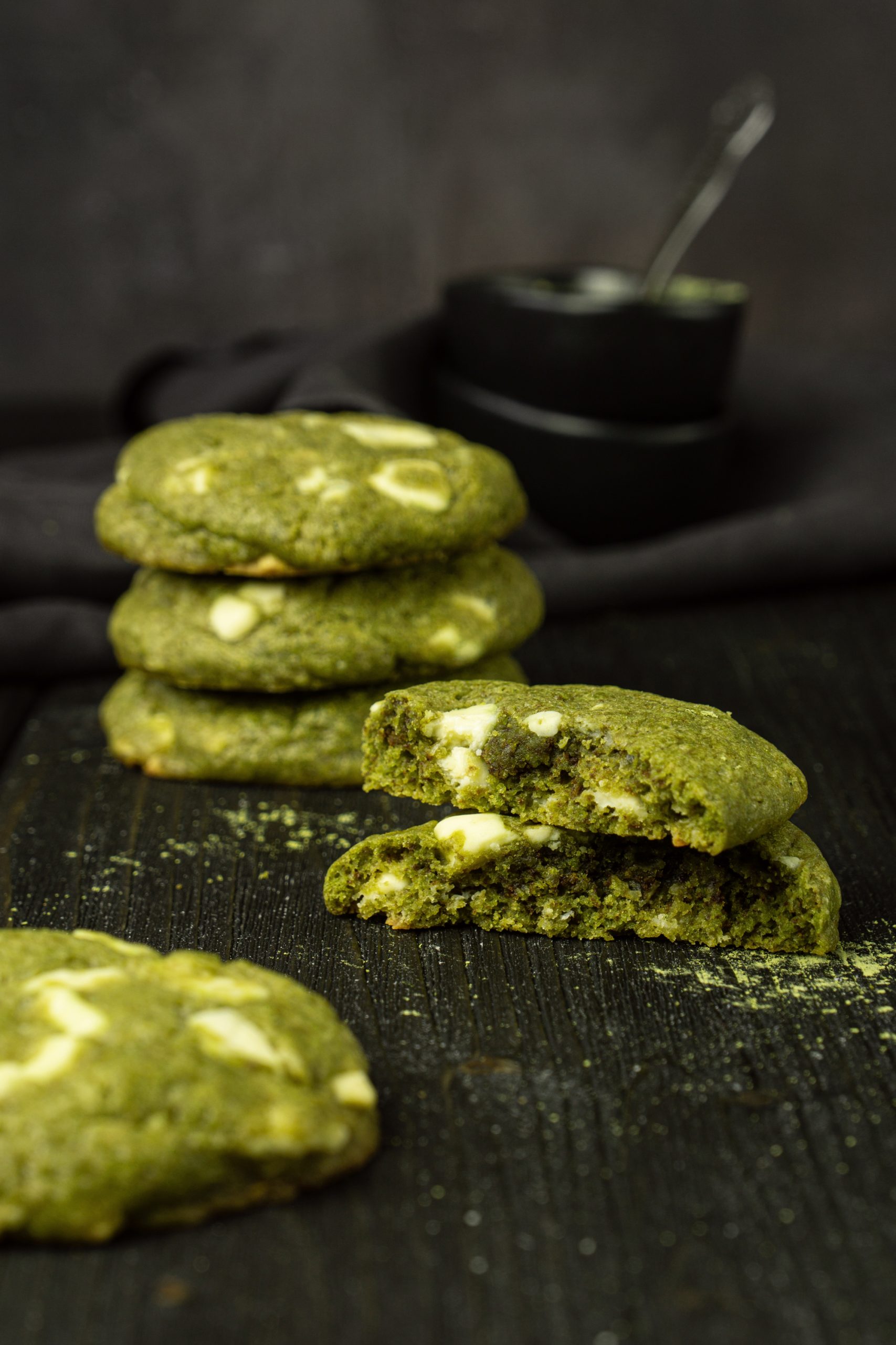Close up of matcha white chocolate chip cookies on a dark background