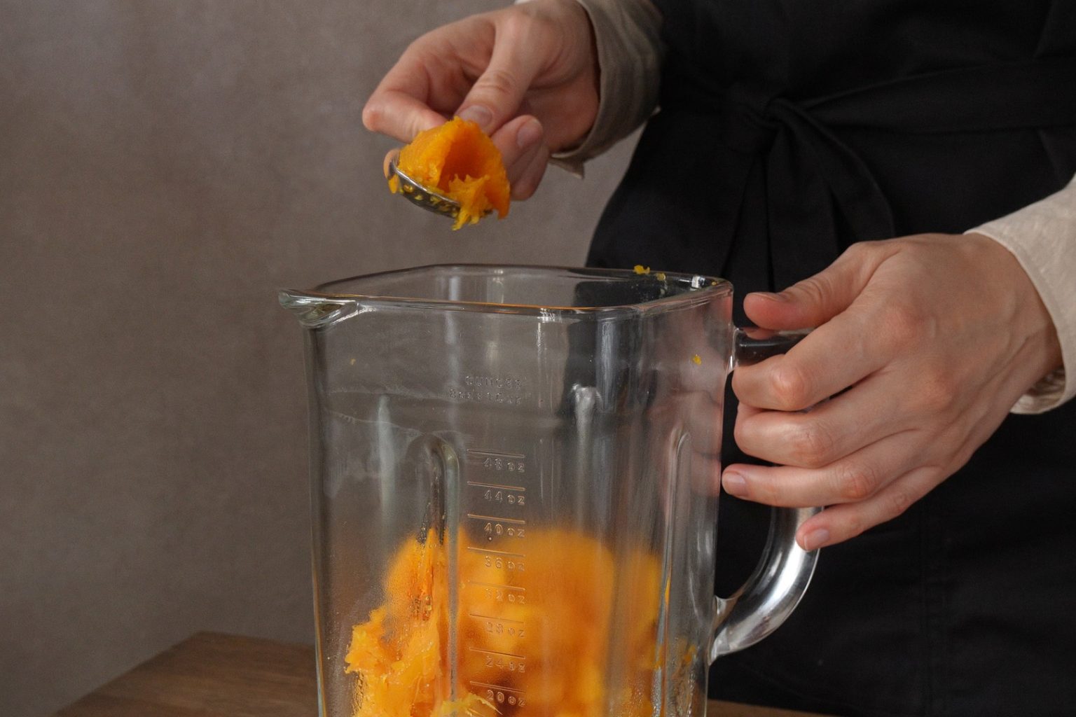 Placing butternut squash flesh into a blender