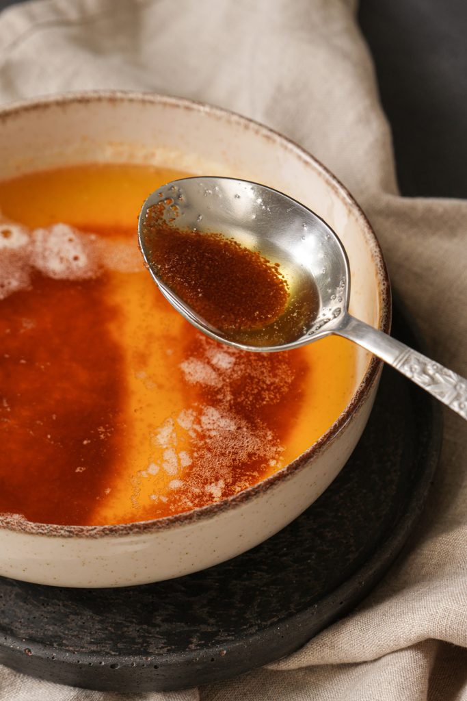 Freshly made liquid brown butter with toasted milk solids in a bowl