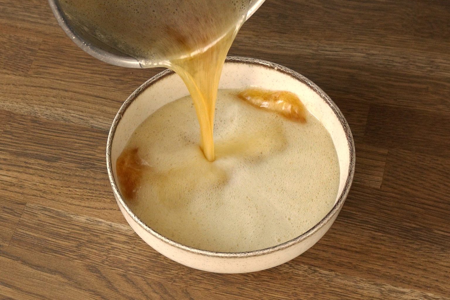 Pouring freshly made brown butter from saucepan into bowl