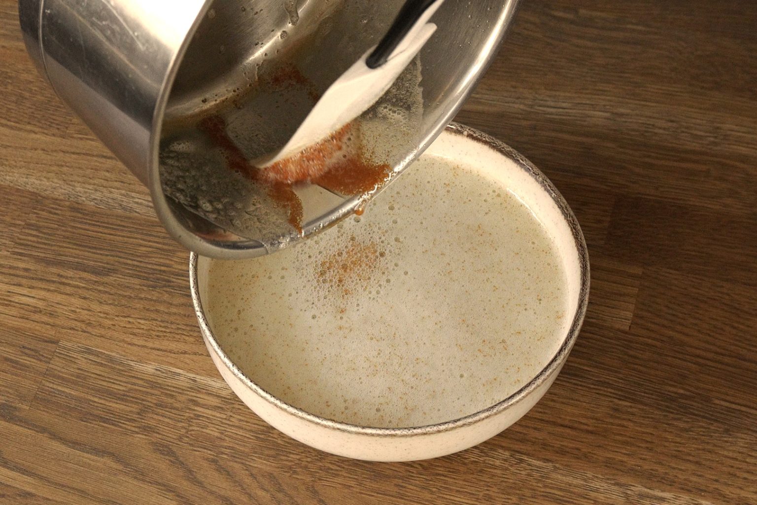 Scraping toasted milk solids form the saucepan