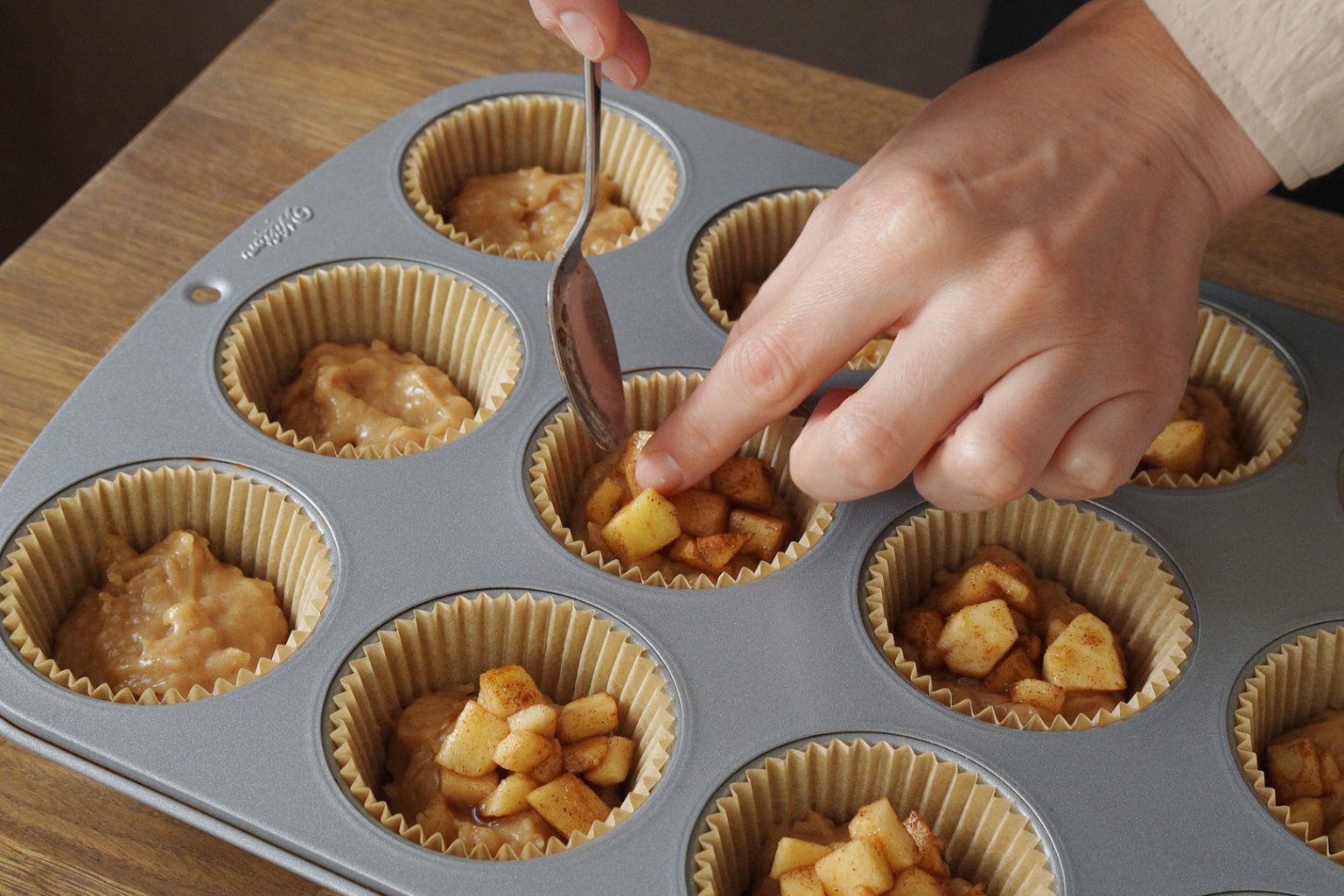 Adding the apple filling into apple muffins