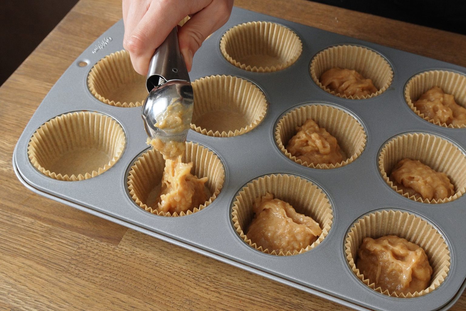 Pouring the muffin batter into a baking pan