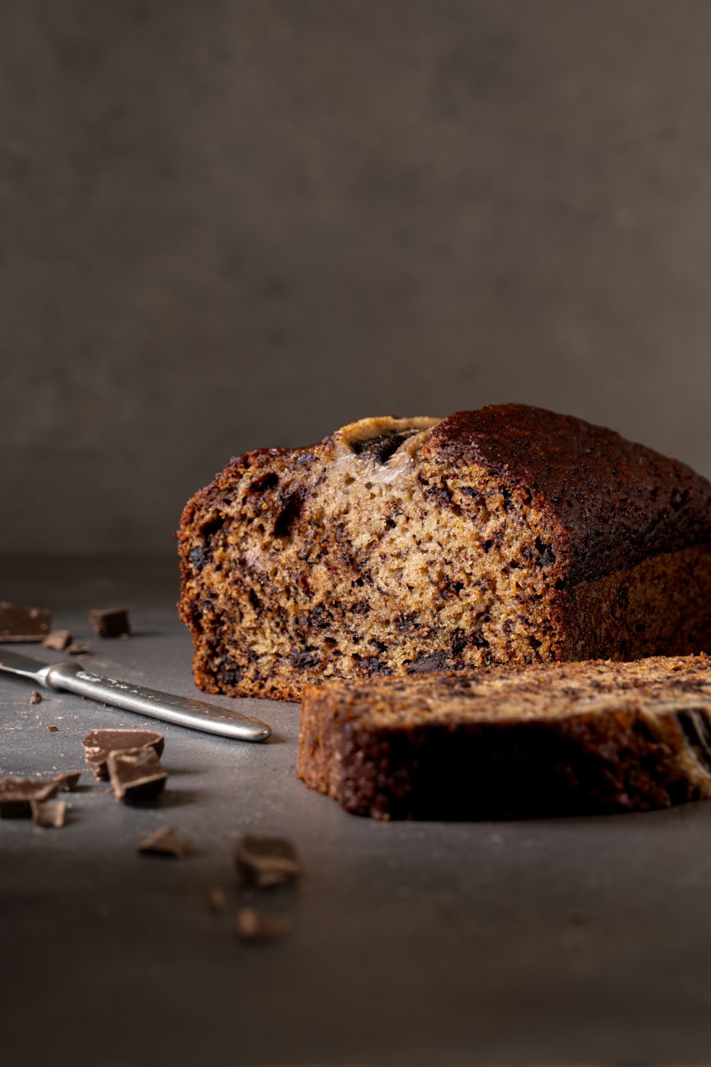 Close-up of a sliced chocolate chip banana bread on a dark background