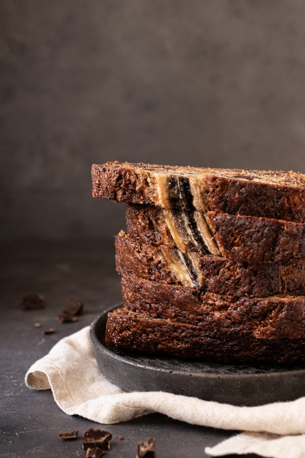 Close-up of a sliced chocolate chip banana bread served on a dark plate