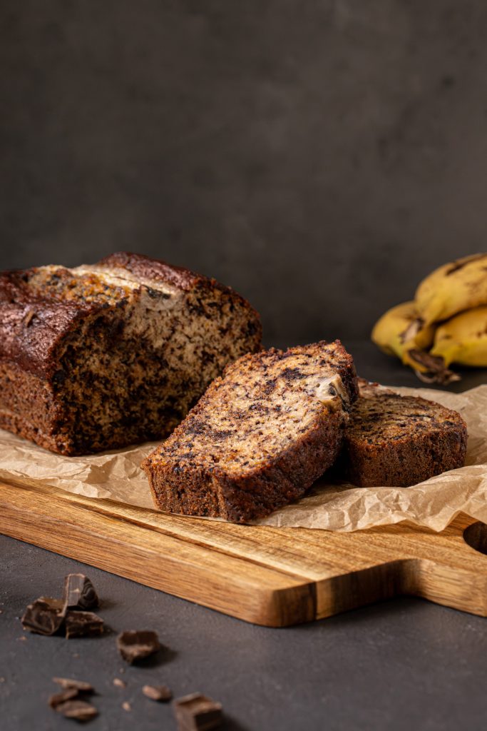 Sliced chocolate chip banana bread served on a wooden board