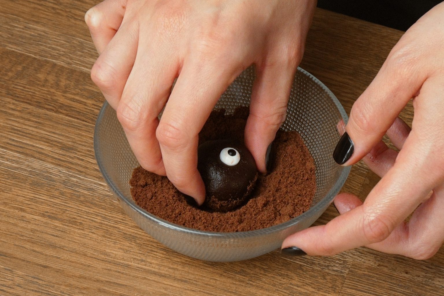Rolling a monster truffle in a dry cookie crumbs