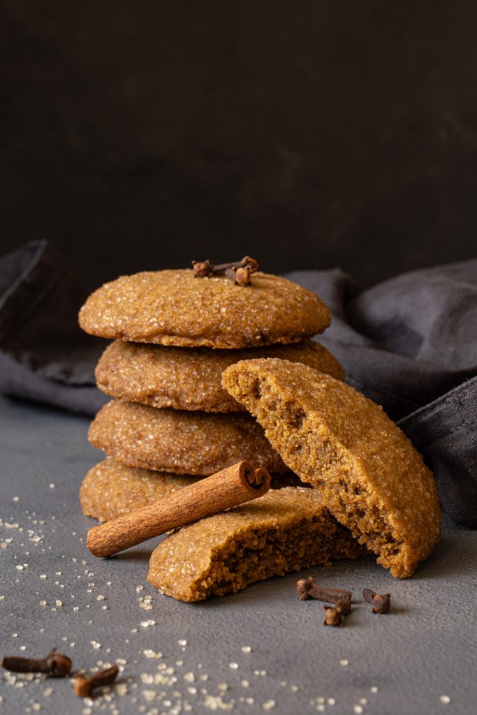 Brown butter pumpkin cookies stacked on a dark background