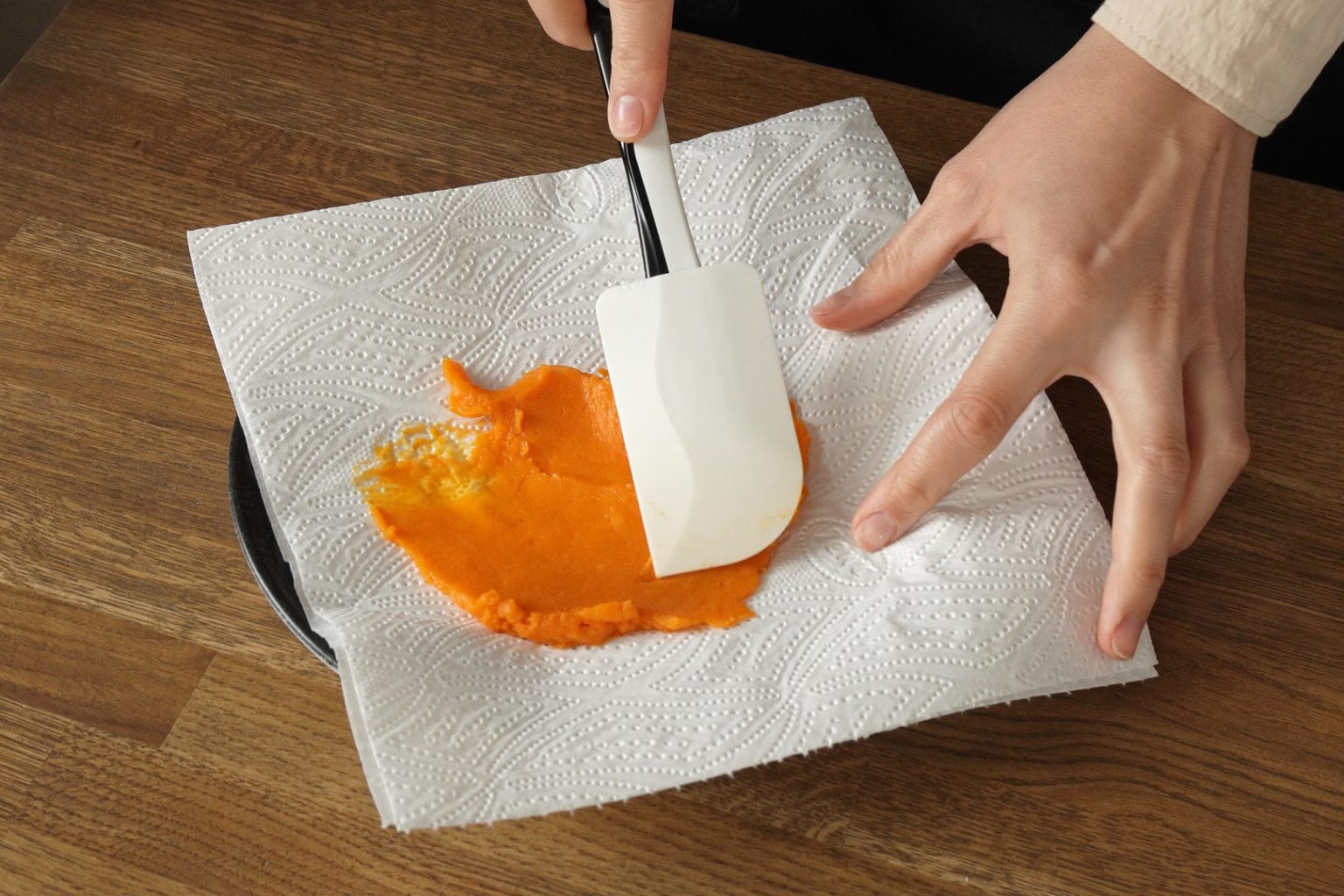 Spreading pumpkin puree on a paper towel