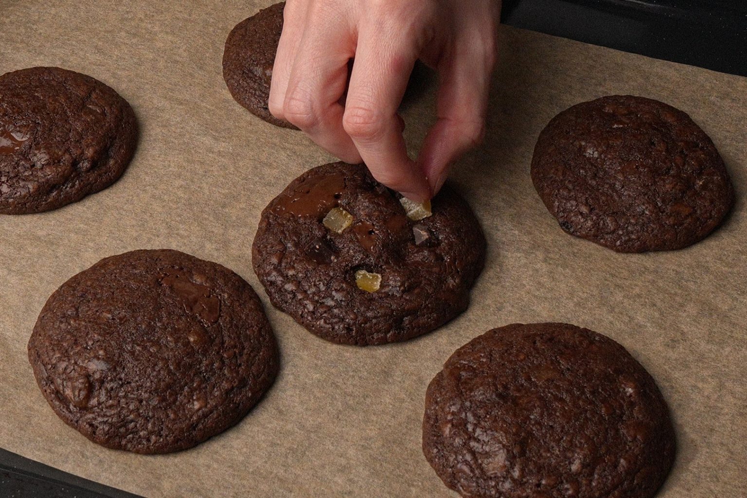 Decorating freshly baked chocolate ginger cookies